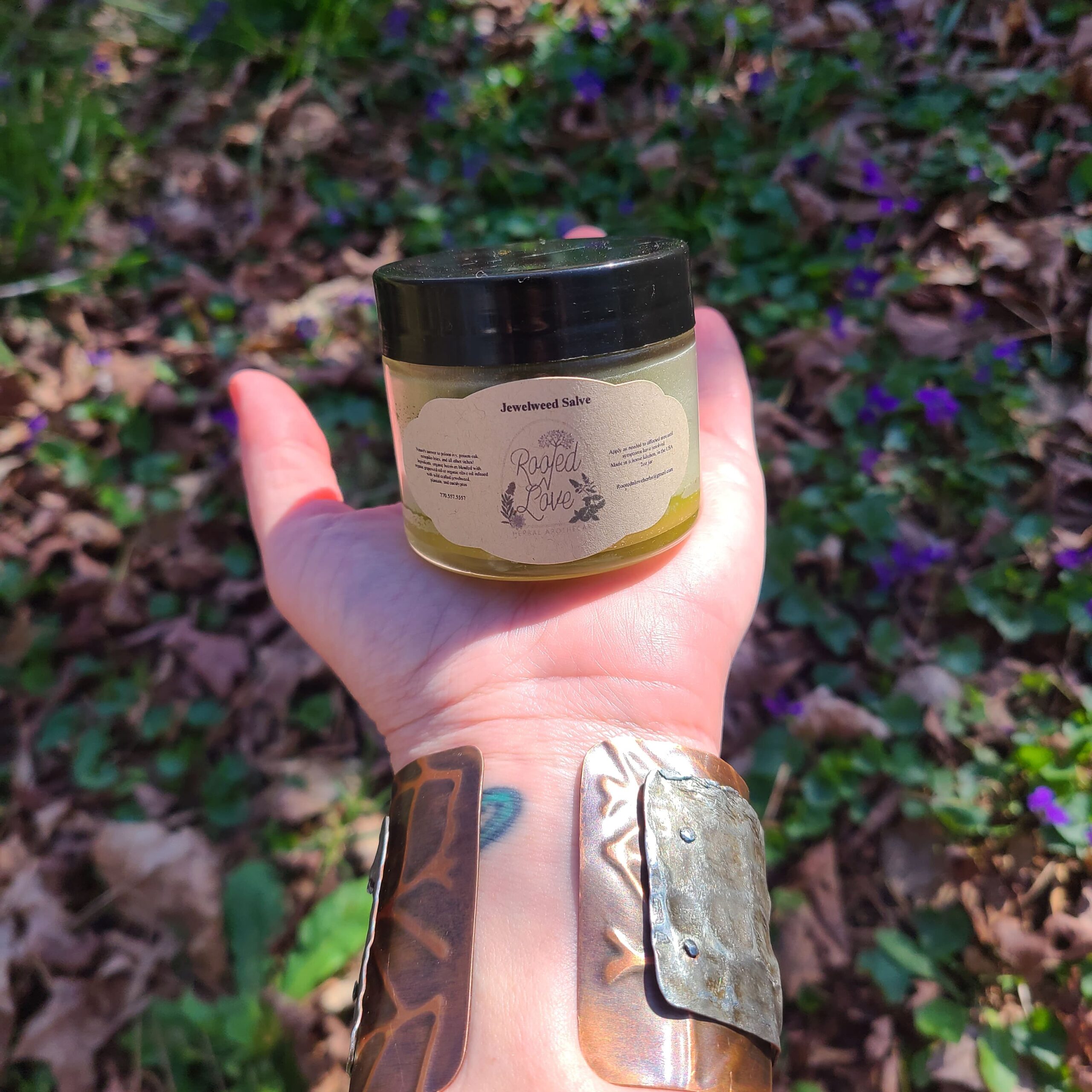 Jar of salve on the palm of a hand